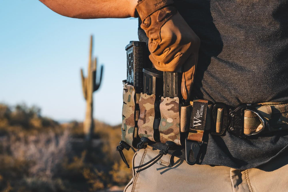 פונדות טקטיות טעונות למחסניות רובה ורובה טקטי חום (עם פנס וידית) פרוסים עם אבזמים ורצועות על רשת הסוואה ירוקה בשטח. - Time to edc.com