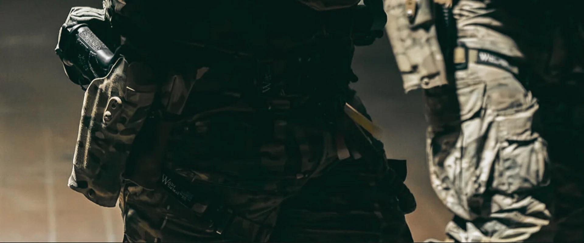 פונדות טקטיות טעונות למחסניות רובה ורובה טקטי חום (עם פנס וידית) פרוסים עם אבזמים ורצועות על רשת הסוואה ירוקה בשטח. - Time to edc.com